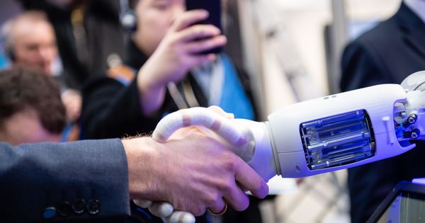 Foto: Un empleado estrecha la mano de un robot en la Feria Industrial en la ciudad alemana de Hannover. (EFE)