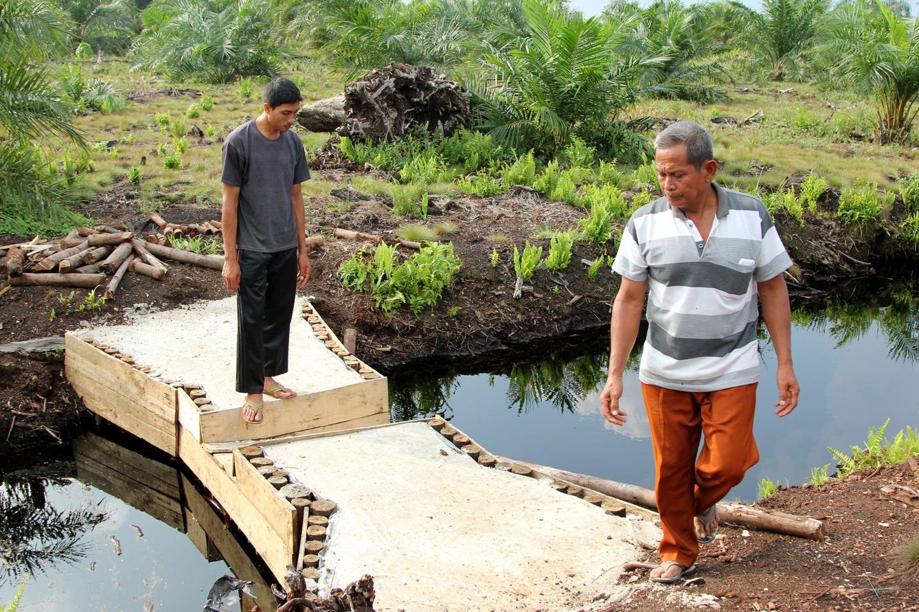 Dos aldeanos inspeccionan una presa recién construida en Jatibaru, Riau, Indonesia (Laura Villadiego).