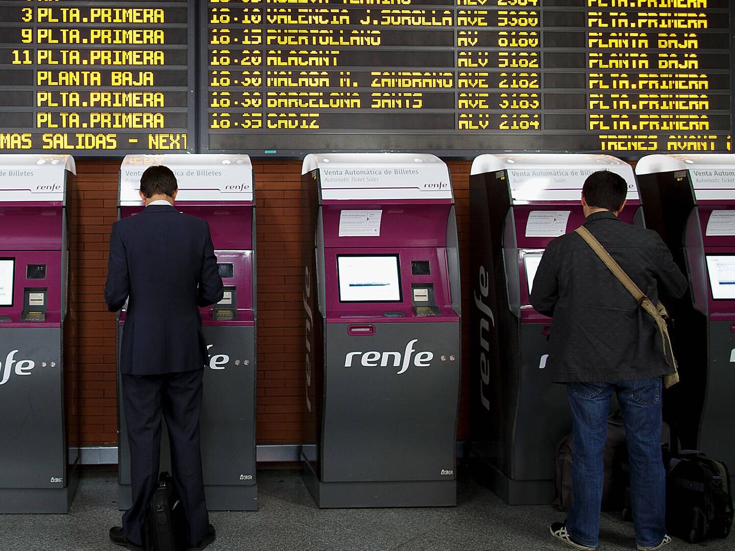 Dos hombres gestionan sus billetes de tren en la estación de Atocha. (Getty/Pablo Blázquez Dominguez)