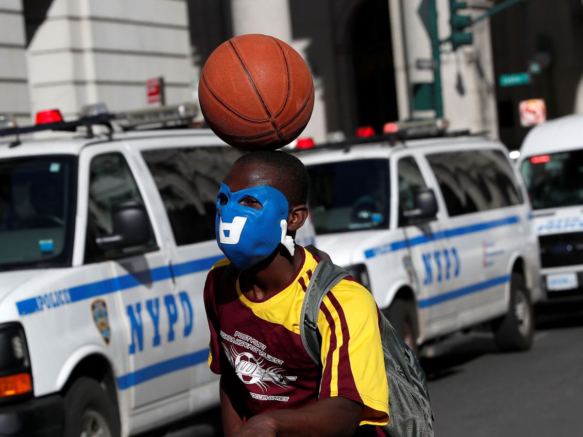 Foto: Un manifestante en Nueva York pasa junto a unos coches de la policía. (Reuters)