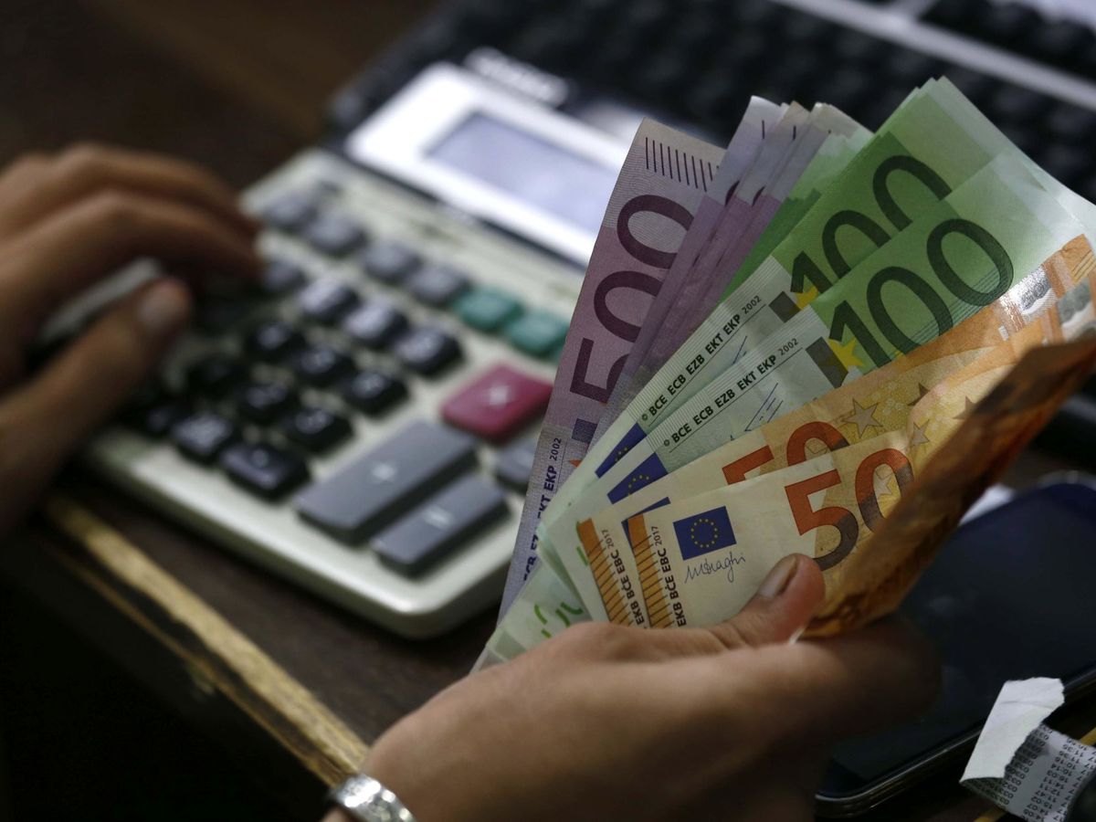 Foto: Intercambio de billetes de euro por dólares. (EFE/Arshad Arbab)