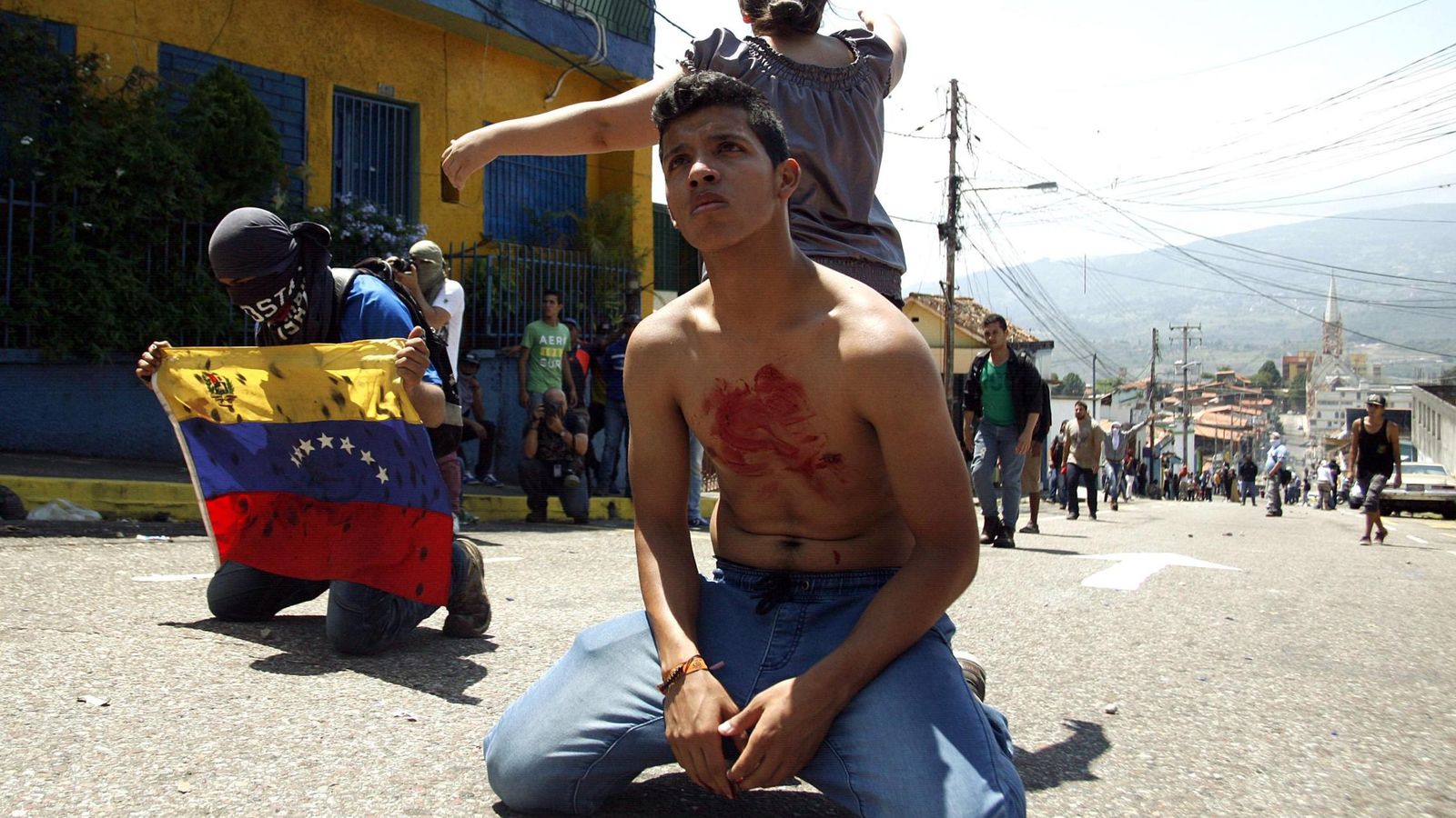 Foto: Un joven, con sangre en su pecho tras la muerte de Kluiberth Roa, de 14 años, durante una protesta antigubernamental en San Cristóbal, el 24 de febrero de 2015. (Reuters)