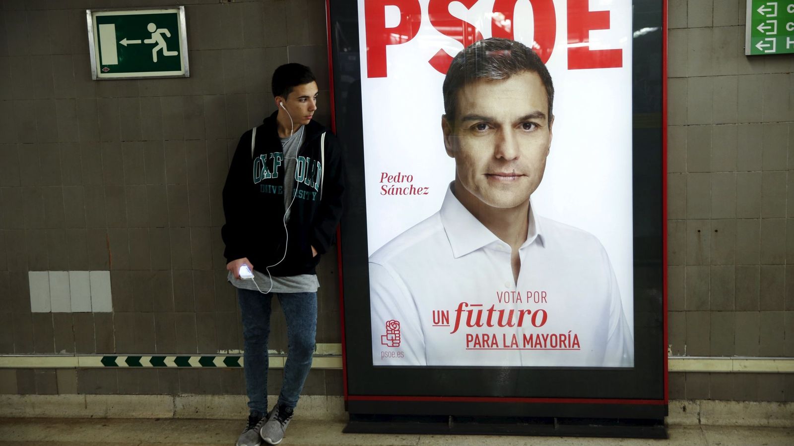 Foto: Un hombre junto un cartel electoral de Pedro Sánchez este 21 de diciembre, en Madrid. (Reuters)