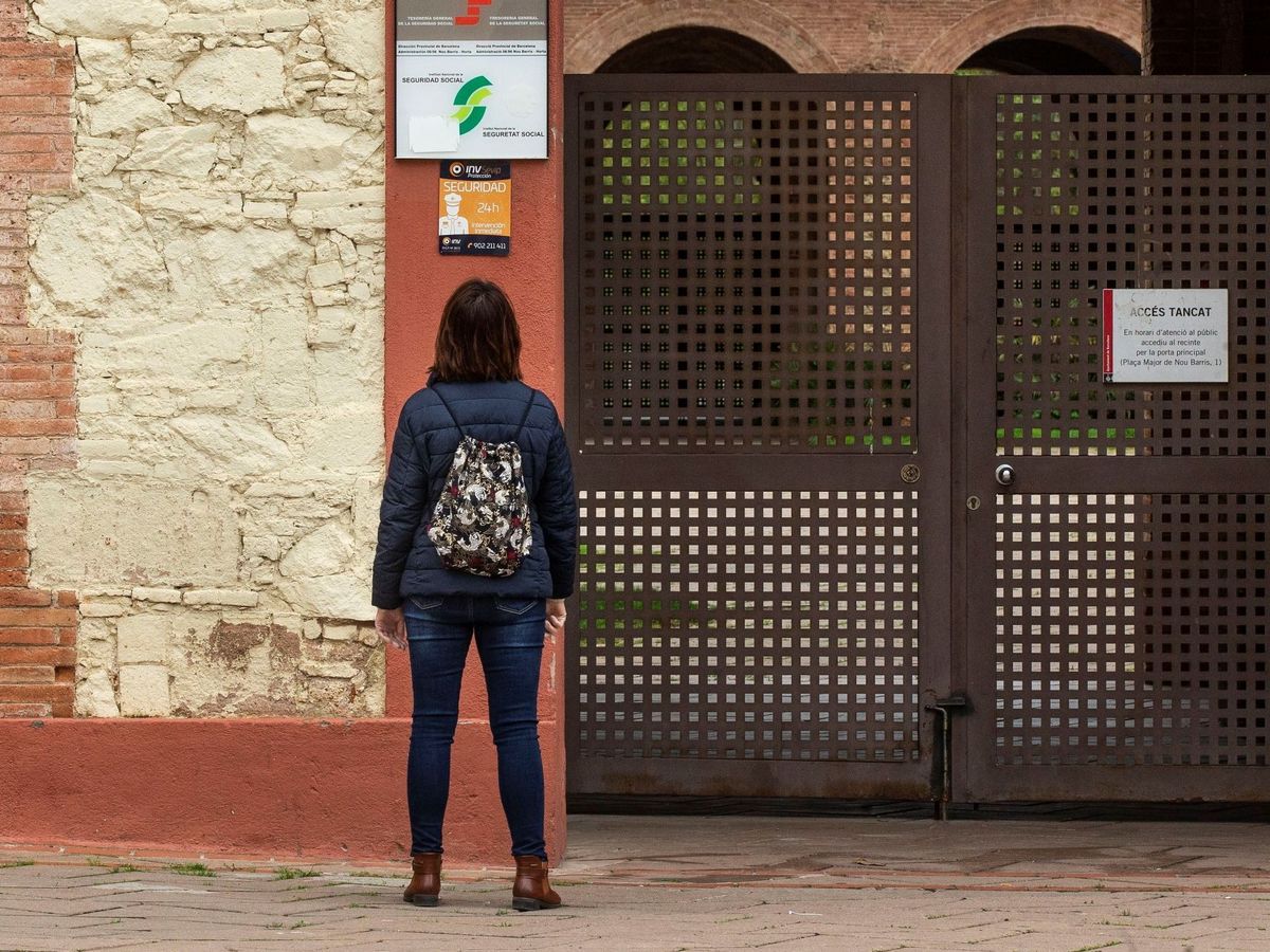 Foto: Una mujer mira el carte de una oficina de la Seguridad Social en Barcelona (EFE)