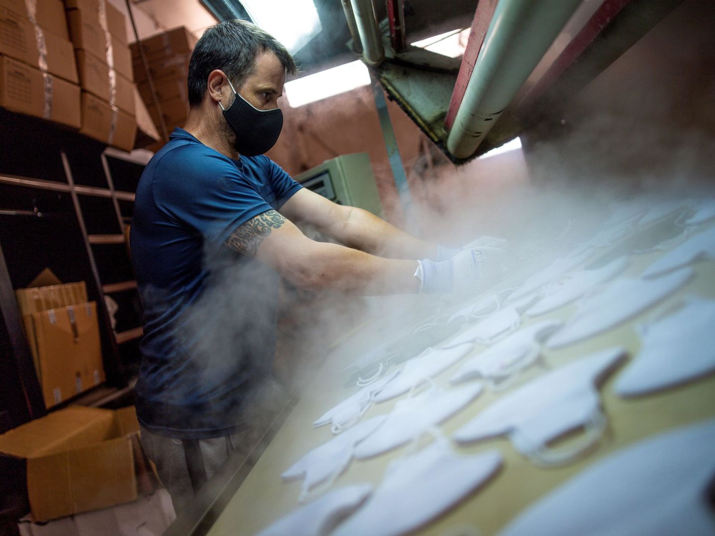 Un empleado fabrica mascarillas en una fábrica de la localidad toledana de Sonseca. (EFE)