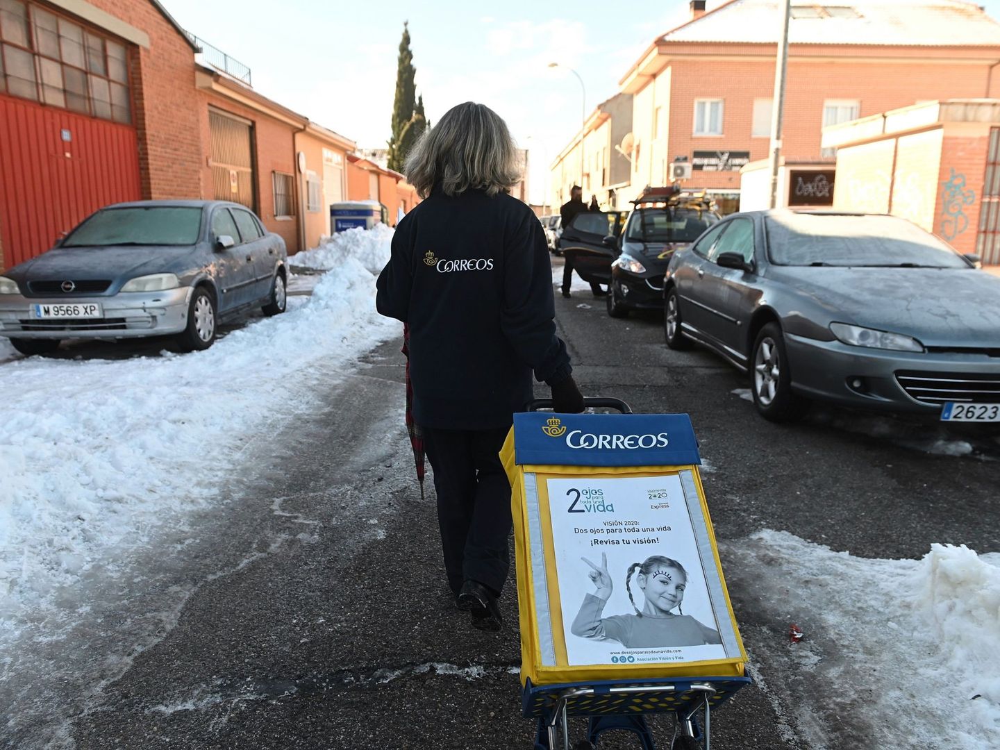 Una trabajadora de Correos reparte cartas en una calle cubierta de hielo. (EFE)