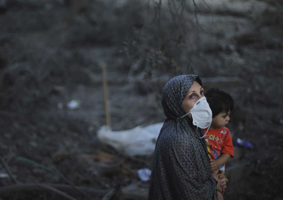 Foto: Una mujer palestina con su hijo pequeño observa el cielo ante los restos de su casa destruida en un bombardeo israelí contra Ciudad de Gaza (Reuters).