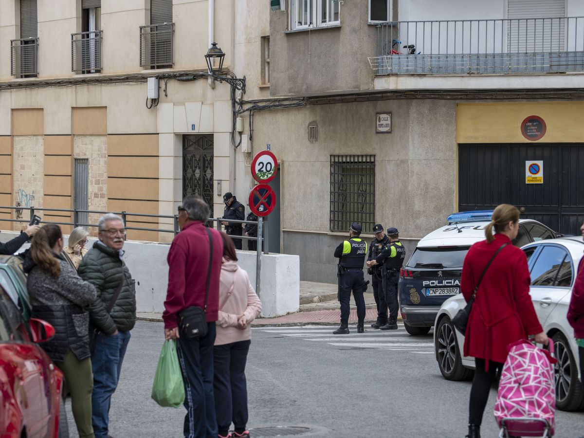 Foto: Policías y vecinos frente a la vivienda en Jaén. (EFE/José Manuel Pedrosa)