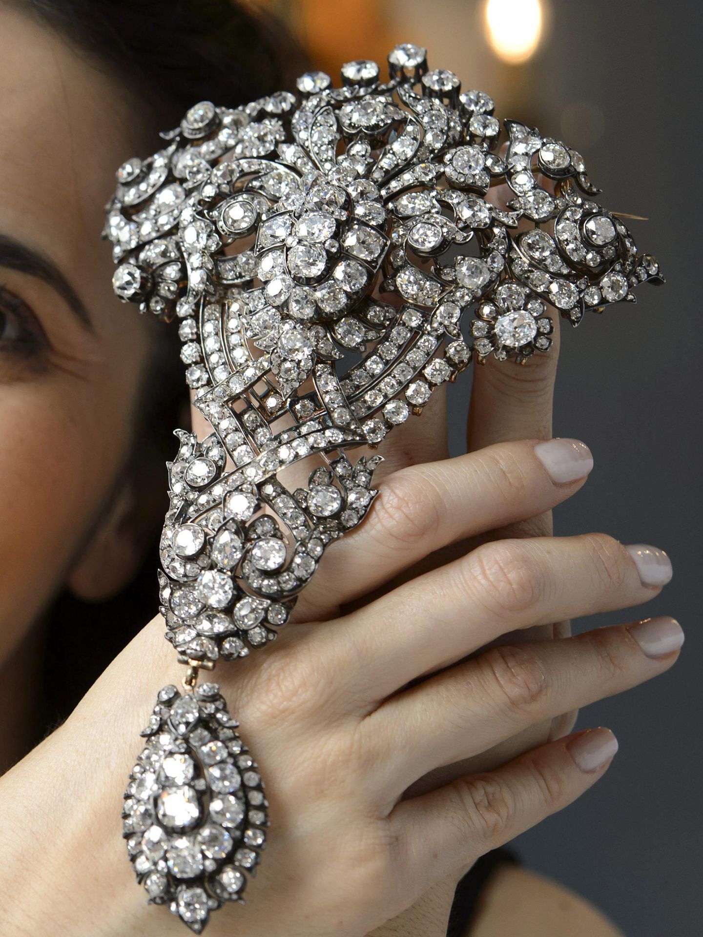 Una empleada de Christies muestra un broche de diamantes 'Devant-de Corsage' (EFE/Martial Trezzini)