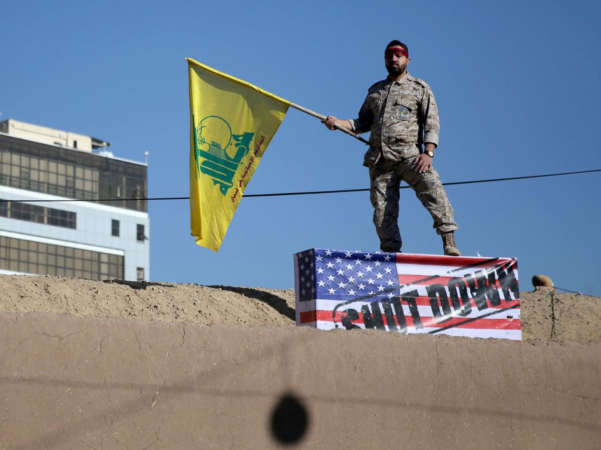 Foto: Un miembro de Hezbolá sostiene una bandera de esta organización islámica durante el funeral del general Soleimani. (Foto: Reuters)