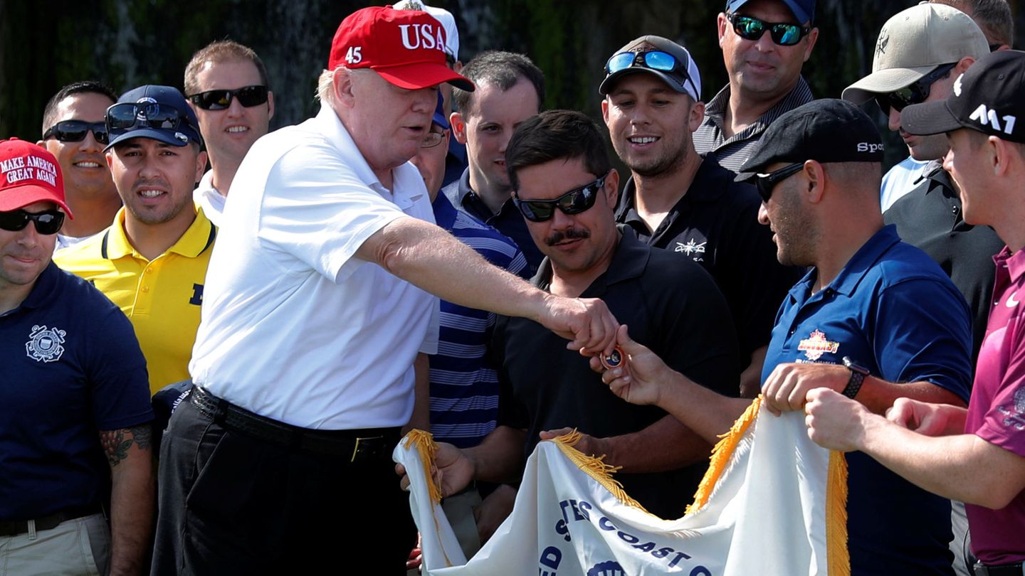 El presidente Donald Trump saluda a miembros de los Guardacostas, invitados a jugar al golf en el Club Internacional Trump en West Palm Beach, Florida, el 29 de diciembre de 2017. (Reuters)