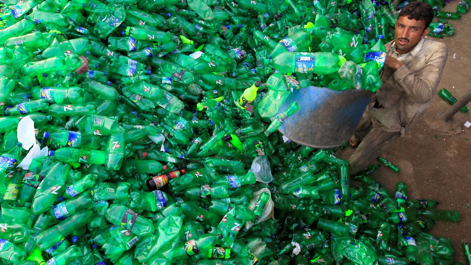 Foto: Un empleado recoge botellas en un taller de reciclaje de Islamabad. (Reuters)