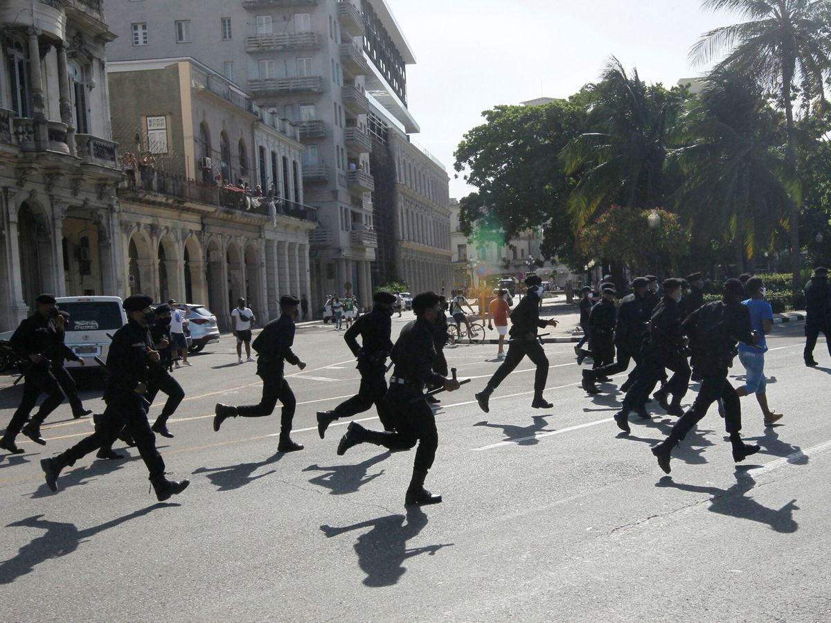 Foto: Agentes de policía corren durante manifestaciones en La Habana. (Reuters)