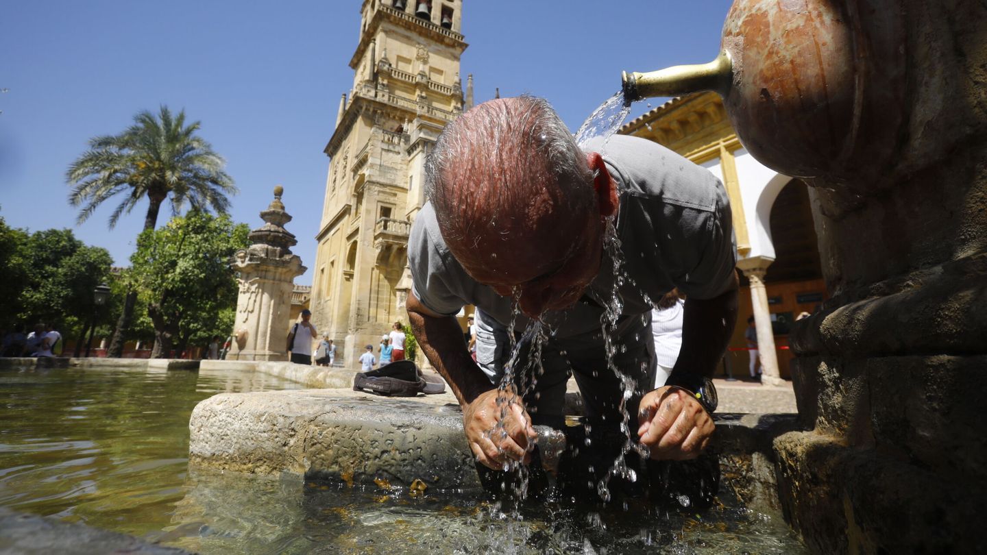 Un hombre se refresca en la fuente del patio de los naranjos de la Mezquita-Catedral de Córdoba hoy lunes, cuando la tercera ola de calor de este verano ha comenzado ya en algunas zonas de Andalucía como el valle del Guadalquivir. (EFE/Salas) 