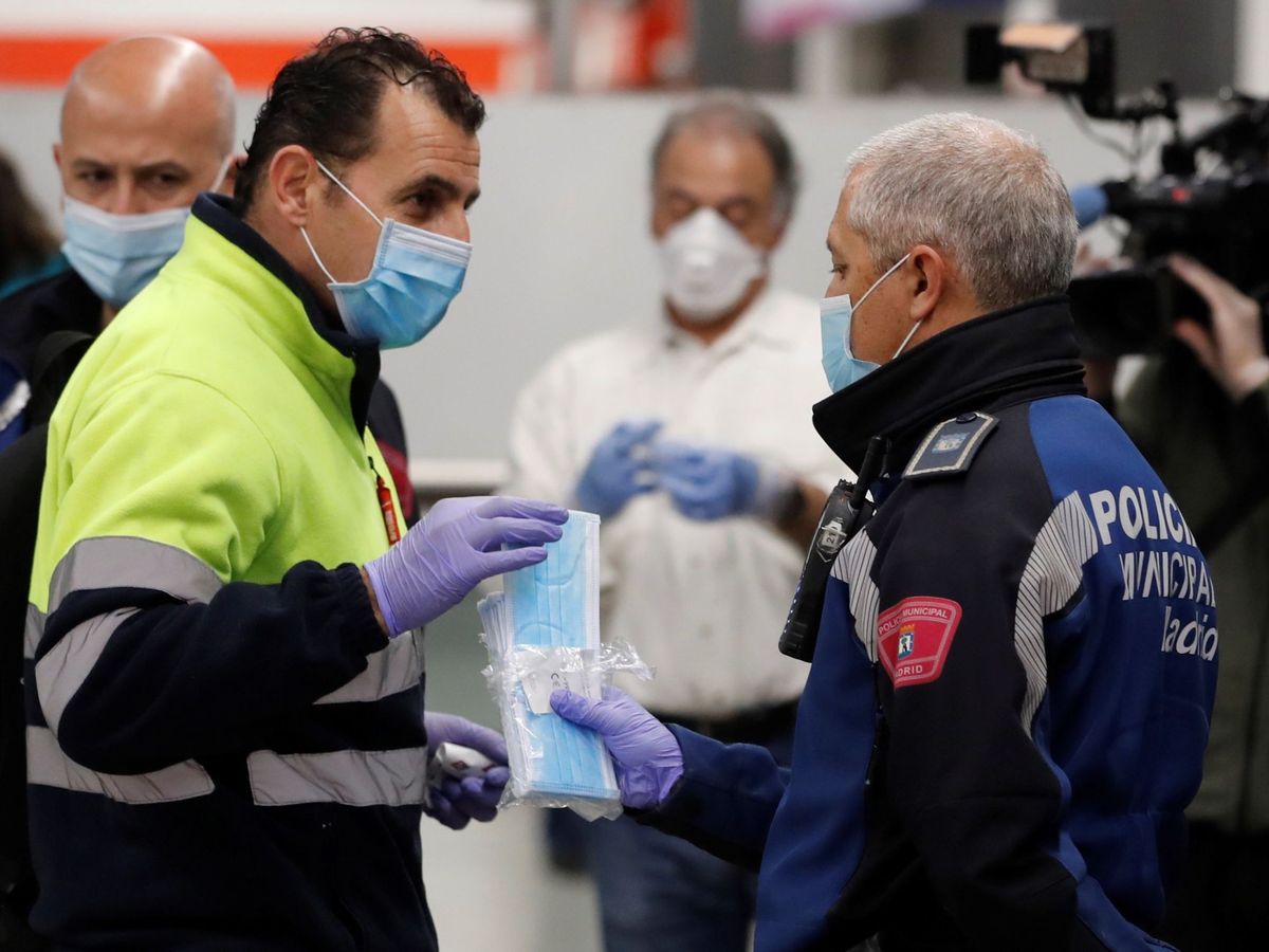 Foto: Policías entregan mascarillas en la estación de metro de Nuevos Ministerios en Madrid. (EFE)