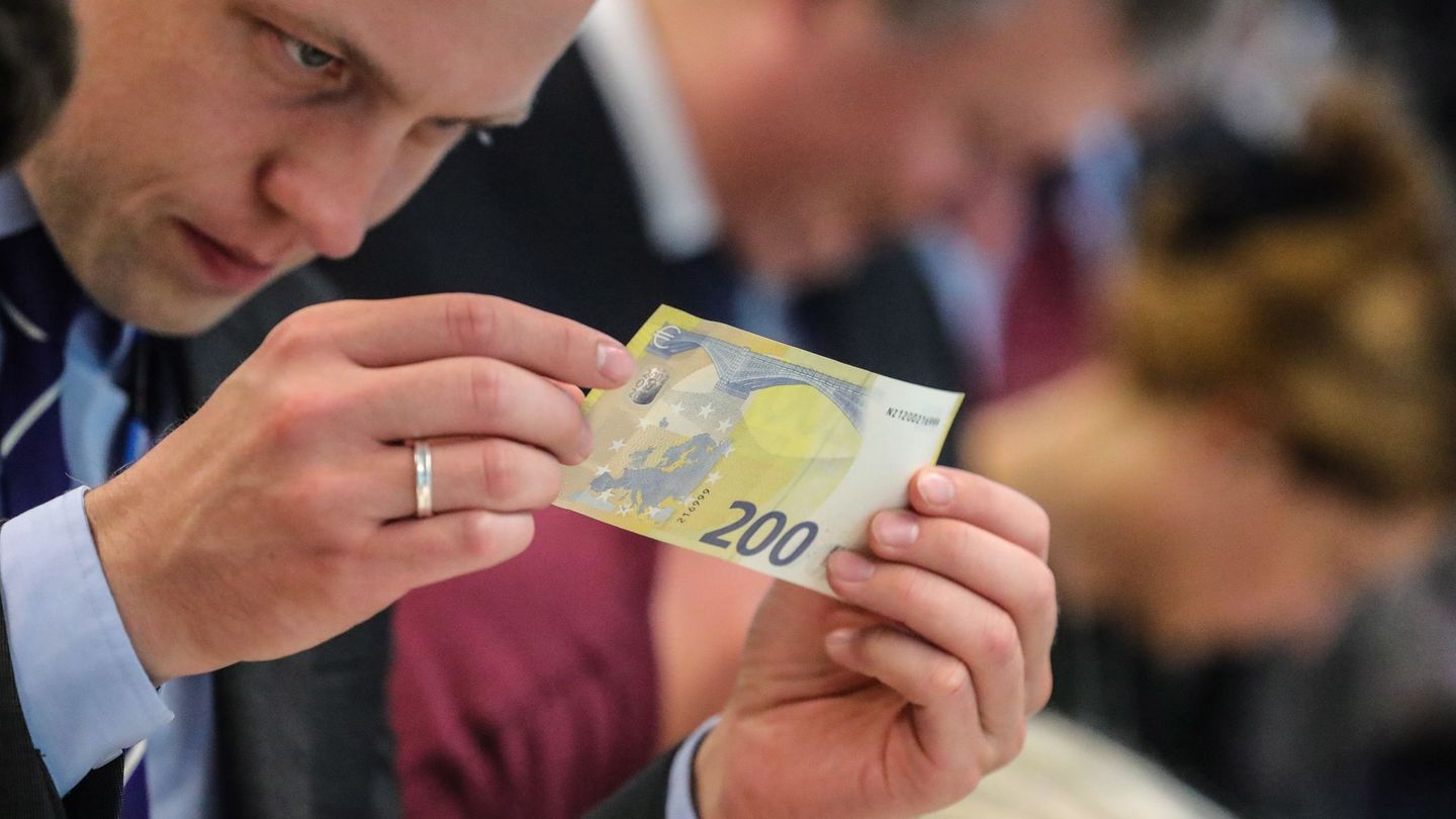 Un periodista inspecciona un nuevo billete de 200 euros. (EFE)
