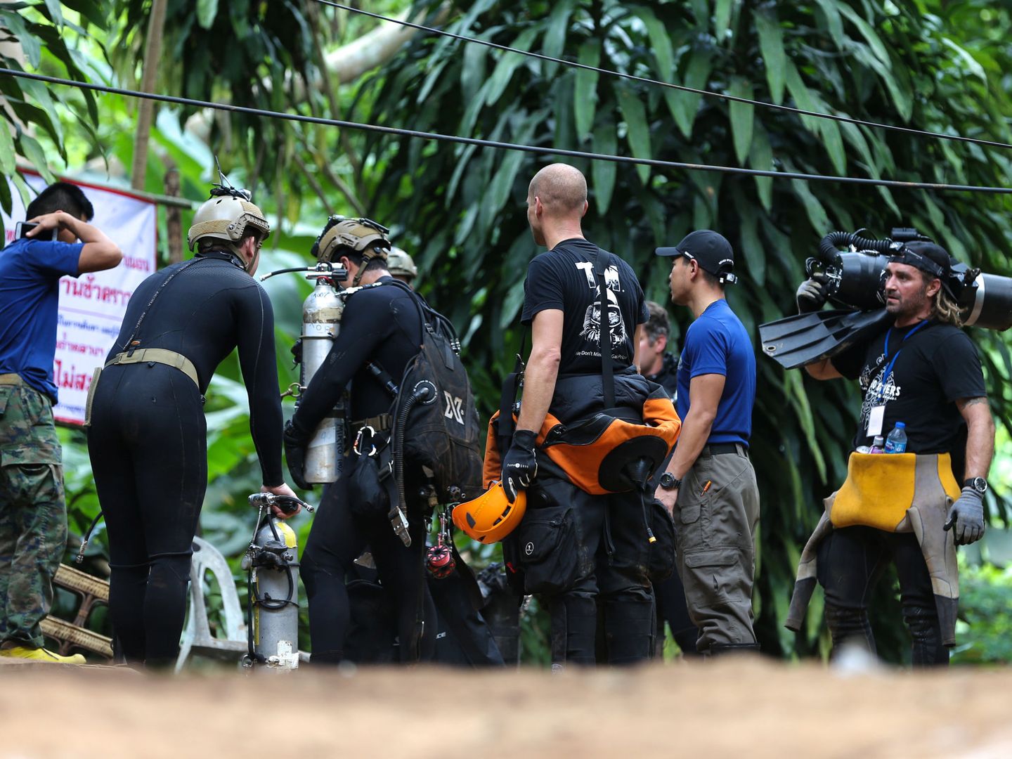 Buceadores tailandeses e internacionales transportan un equipo de inmersión hacia el interior de la cueva de Tham Luang. (Reuters)