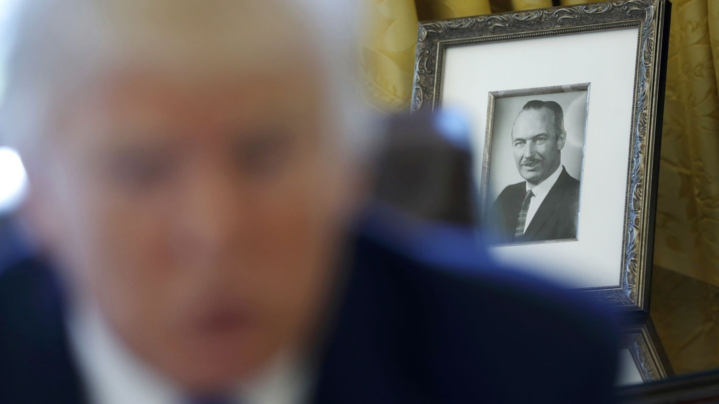 Donald Trump da una entrevista con el retrato de su padre, Fred, de fondo. (Reuters)