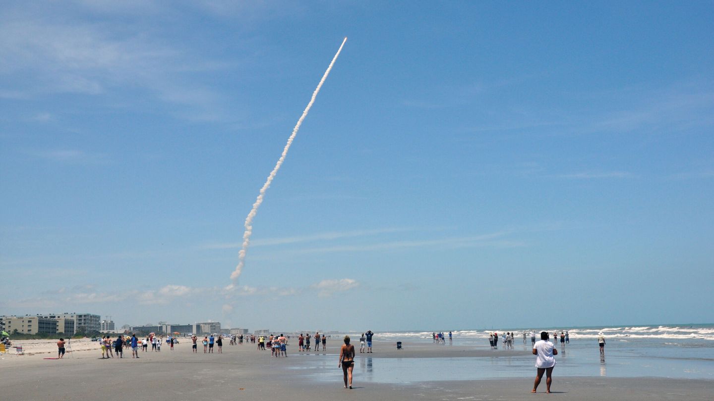 Personas mientras observan el lanzamiento de un cohete desde la playa de Cocoa Beach, al sur de la Estación de la Fuerza Aérea de Cabo Cañaveral en Florida (Estados Unidos). (EFE/Oficina Turismo Costa Espacial Florida)
