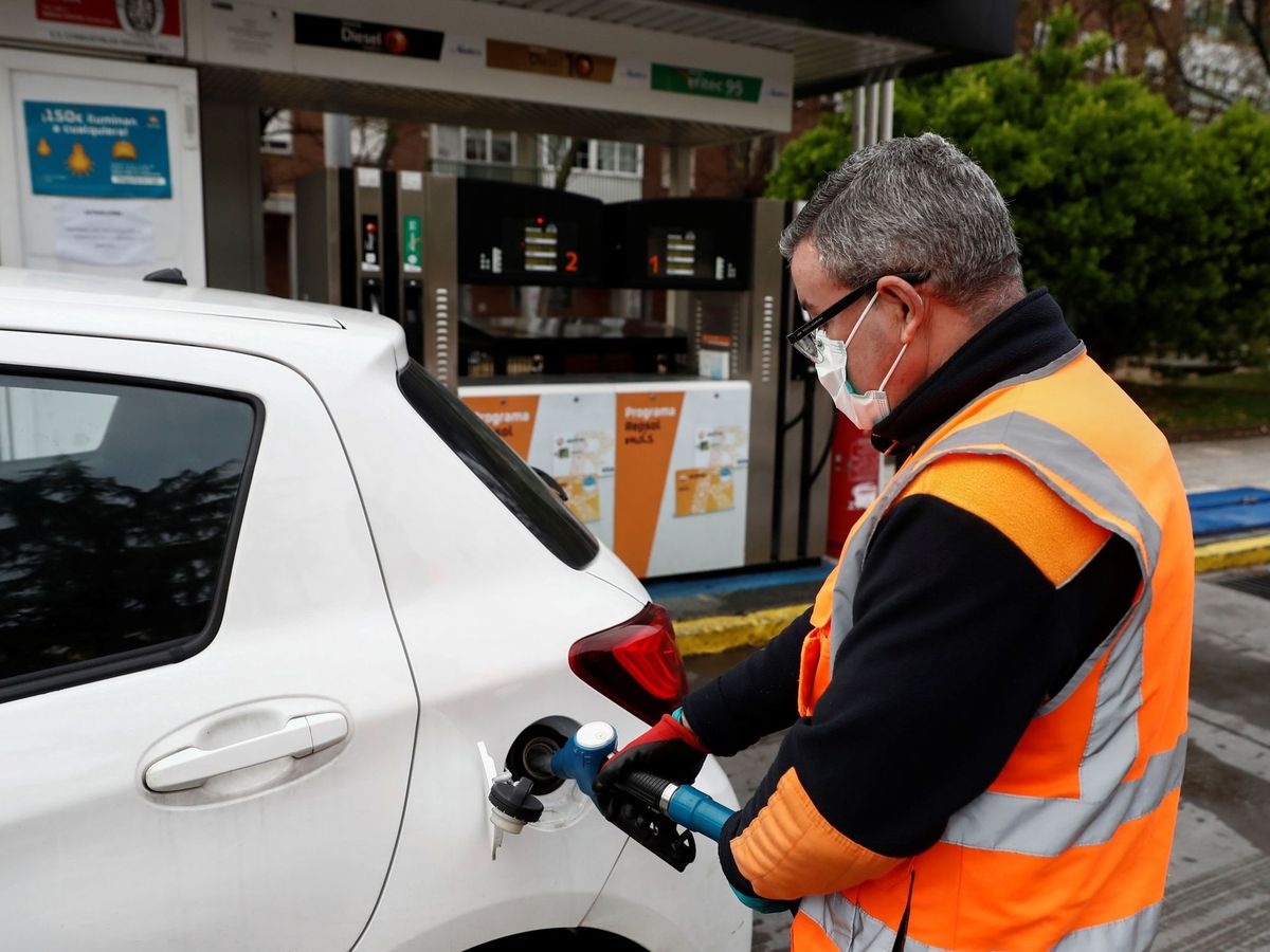 Foto: Un empleado de una gasolinera de Madrid llena el depósito de un vehículo. (EFE)