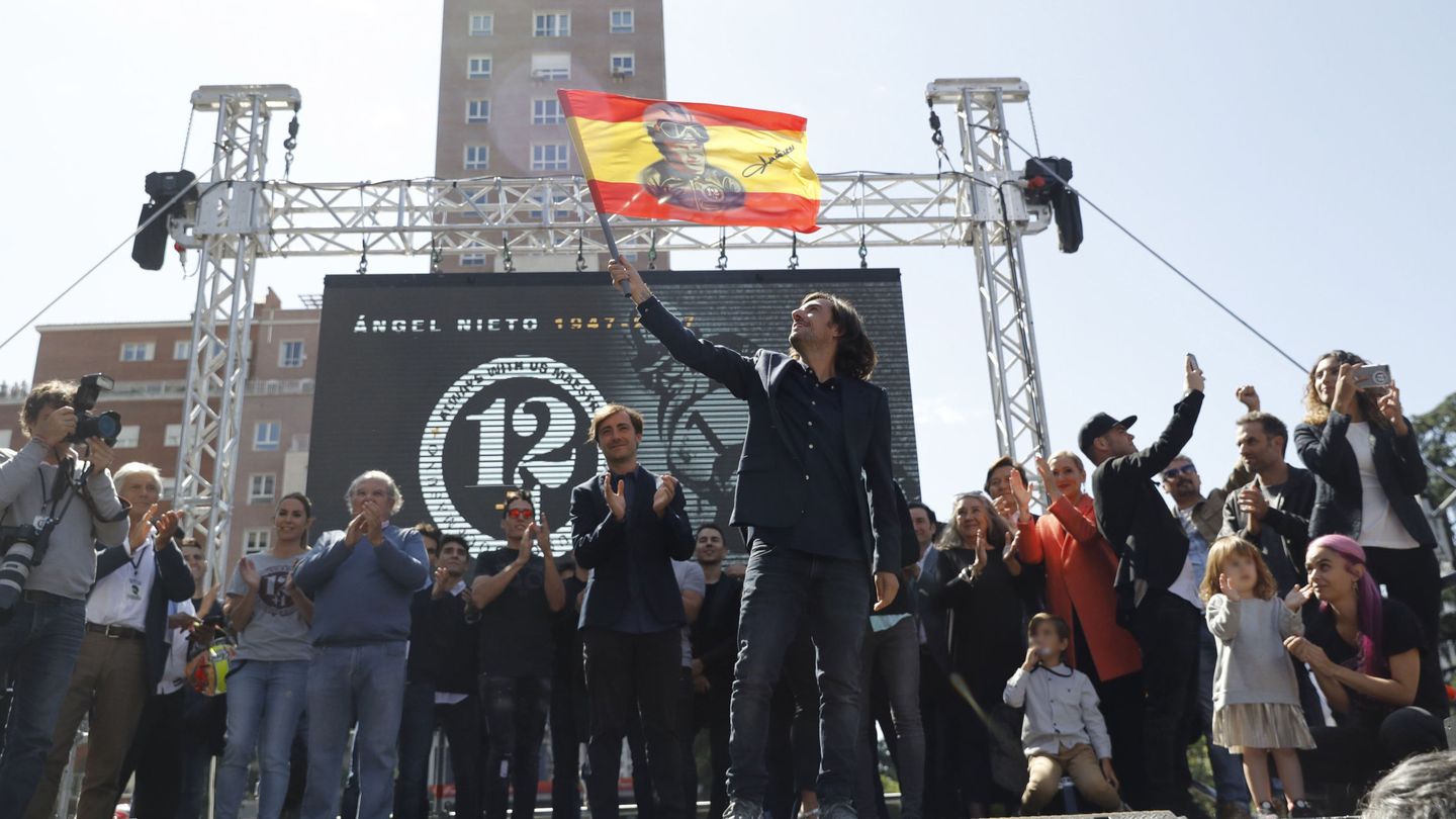 Uno de los hijos de Ángel Nieto enarbola la bandera de España en un homenaje. (EFE)