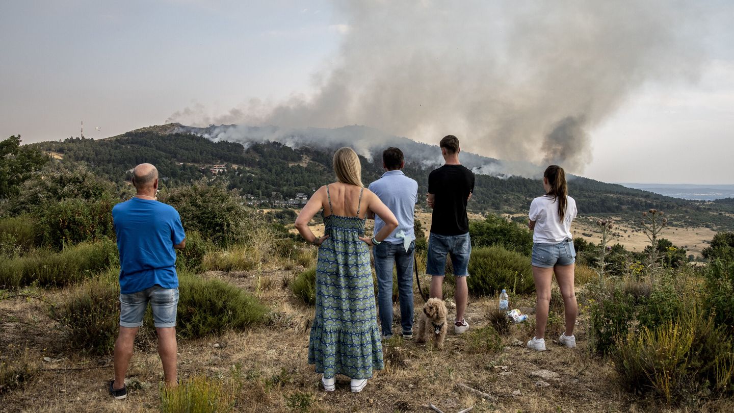 Varios vecinos observan la evolución del incendio de Collado Mediano. (EFE/Ismael Herrero)