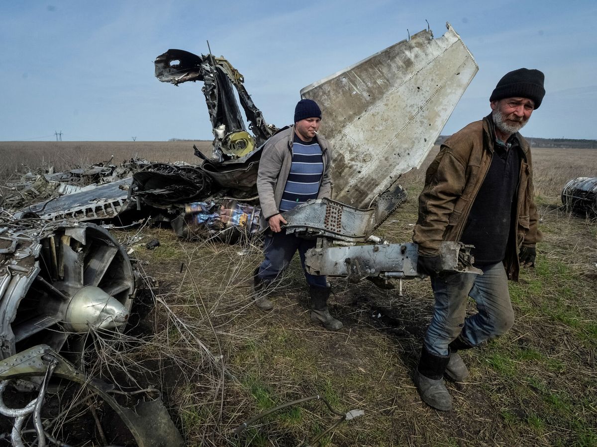 Foto: Ciudadanos de Járkov se llevan la chatarra de un avión militar destruido. (Reuters/Oleksandr Klymenko)