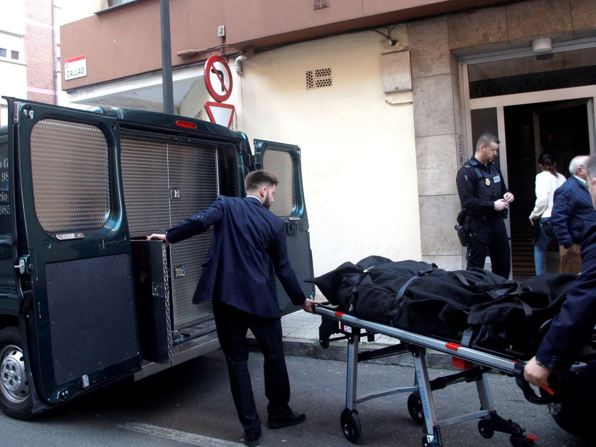 Foto: Dos personas trasladan el cadáver de una mujer de 41 años, hallado este lunes por la Policía Local de Gijón con evidentes signos de violencia. (EFE)