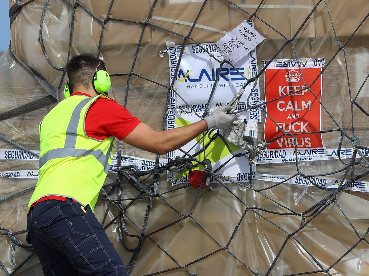 Foto: Un operario del aeropuerto de Gran Canaria descarga un avión con material sanitario adquirido por el Gobierno de Canarias en China. (EFE/Elvira Urquijo A.)