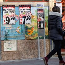 Foto: Una mujer camina frente a una charcutería en Madrid. (Chema Moya/EFE)
