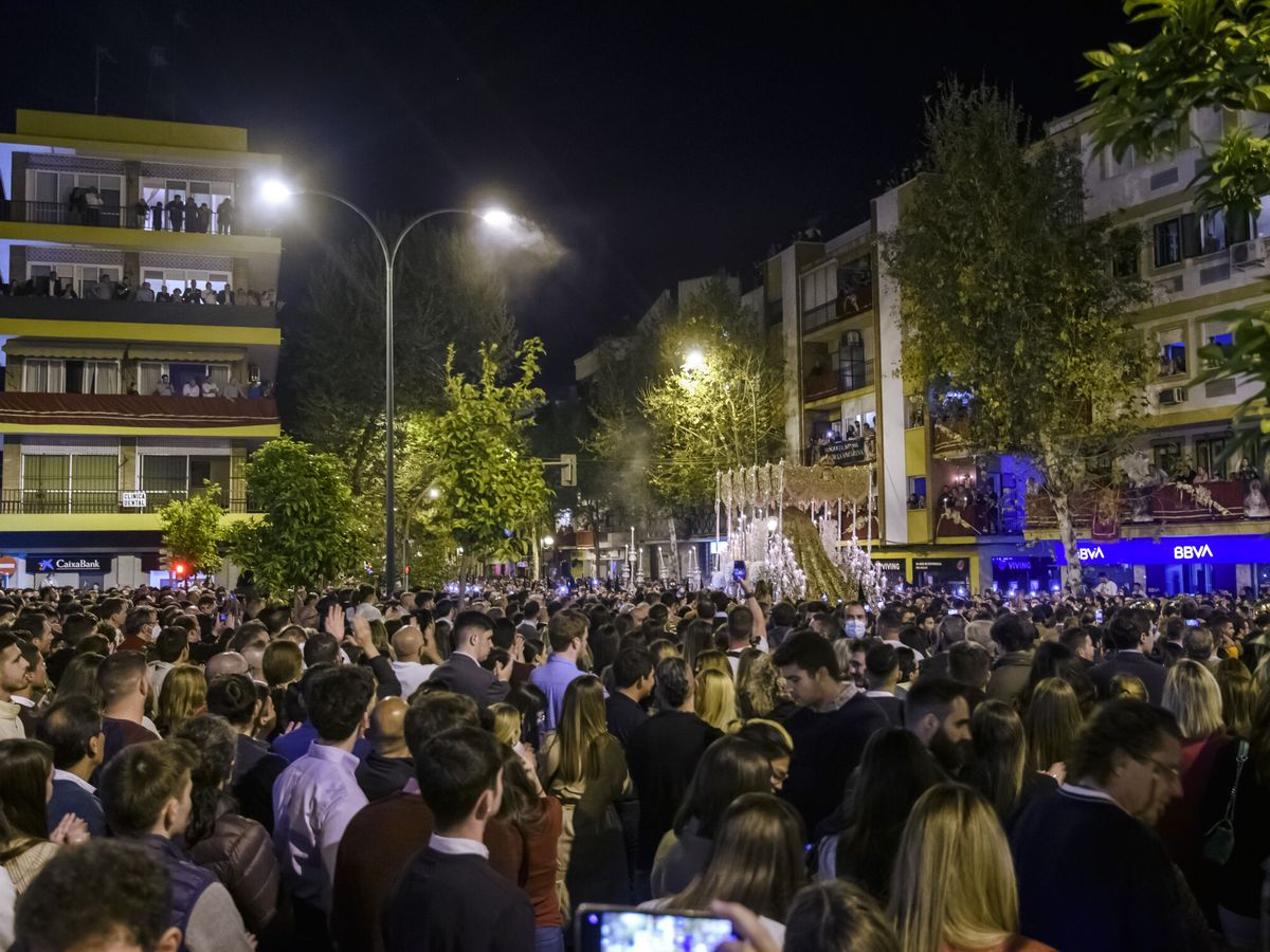 Foto: Aglomeración de personas al paso de la Esperanza Macarena, en la calle Resolana. (EFE/Raúl Caro)