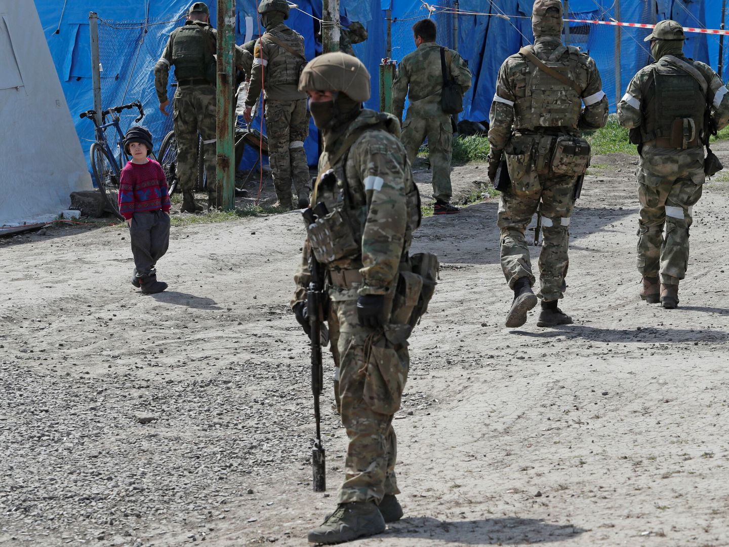 Un niño, entre soldados en el operativo de salida de Azovstal. (Reuters)