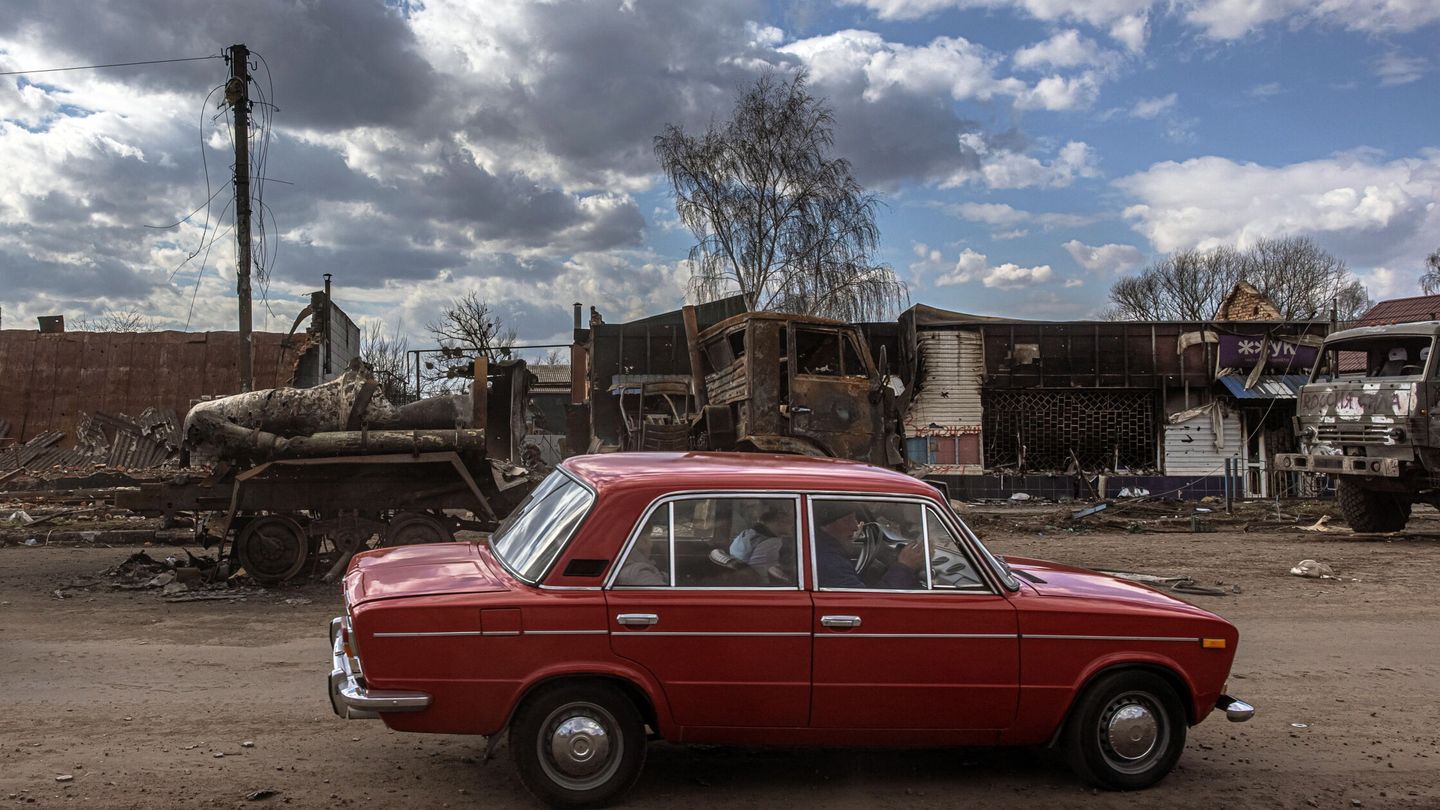 Un automóvil pasa junto a vehículos militares rusos destruidos, en la región de Sumy. (EFE/ROMAN PILIPEY)