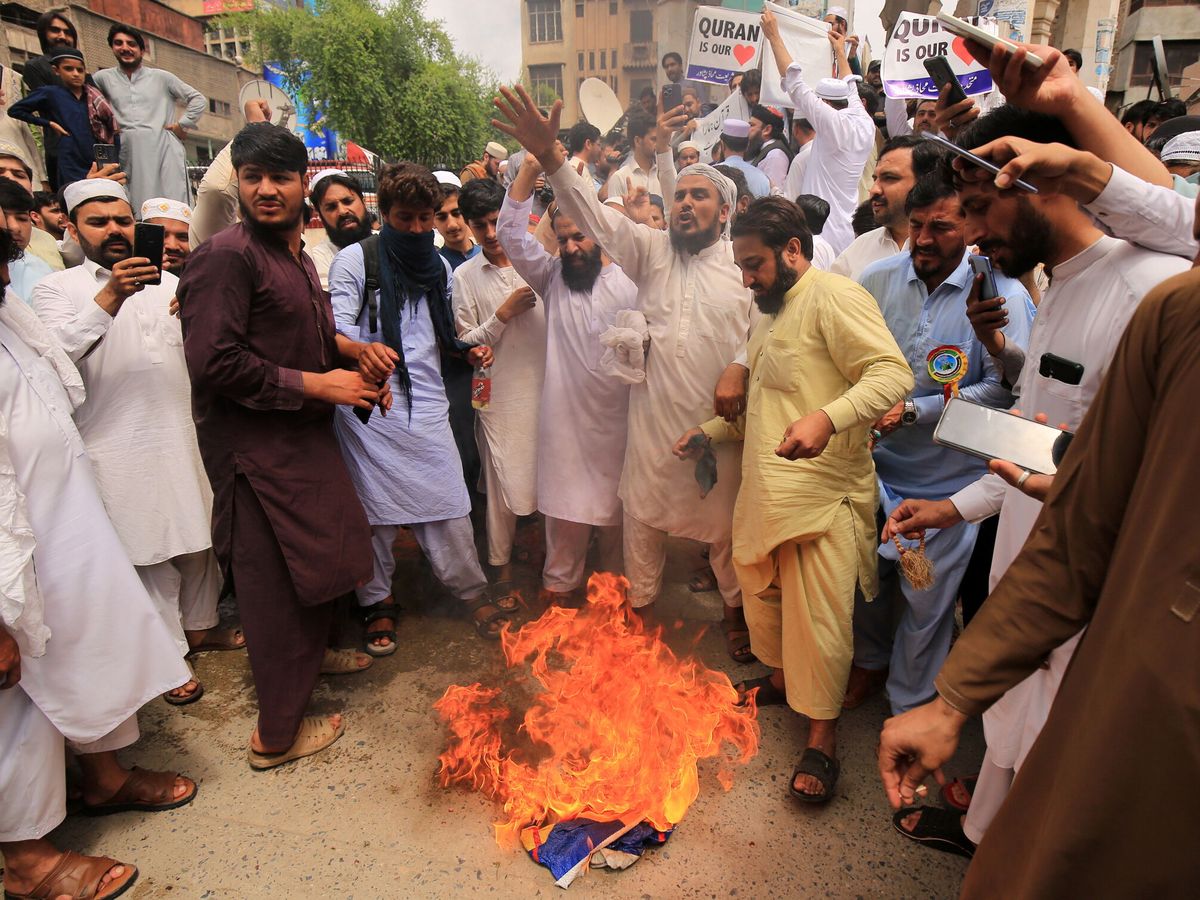 Foto: Varias personas queman en Pakistán una bandera de Suecia durante unas protestas en contra de la quema de un Corán. (EFE/Bilawal Arbab)