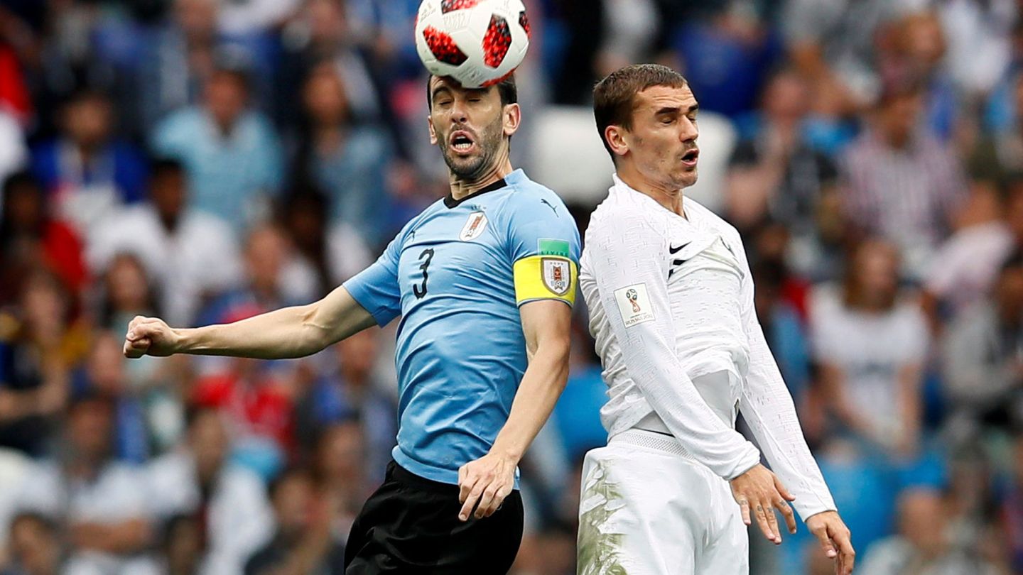 Diego Godín y Antoine Griezmann disputan el balón durante una jugada (Reuters)