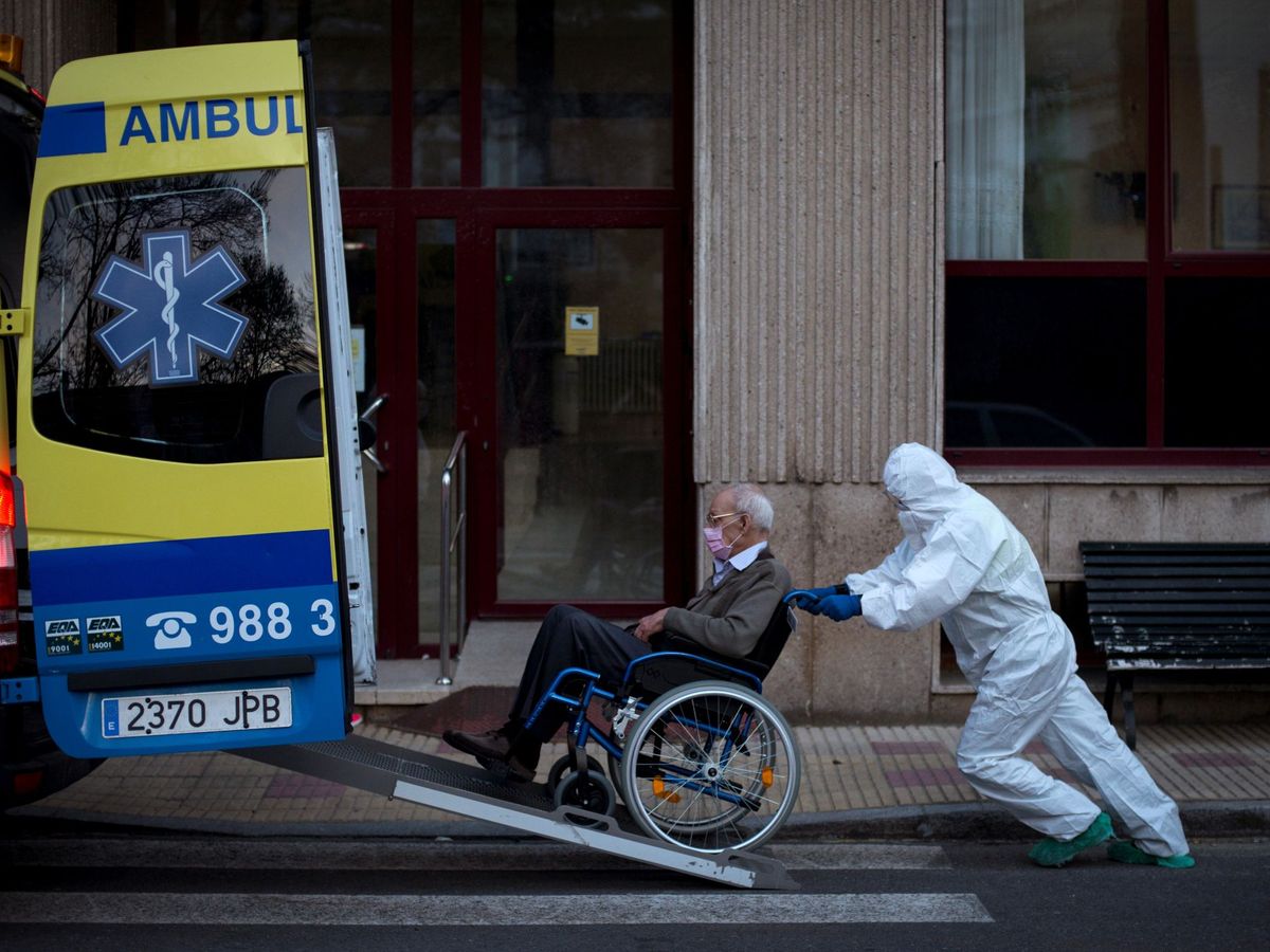 Foto: Un trabajador traslada a un anciano en una residencia gallega. (EFE)