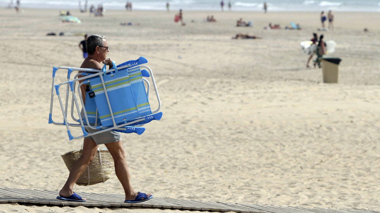 Foto: Un hombre se dirige a la playa de la Barrosa, en Chiclana, Cádiz (EFE)