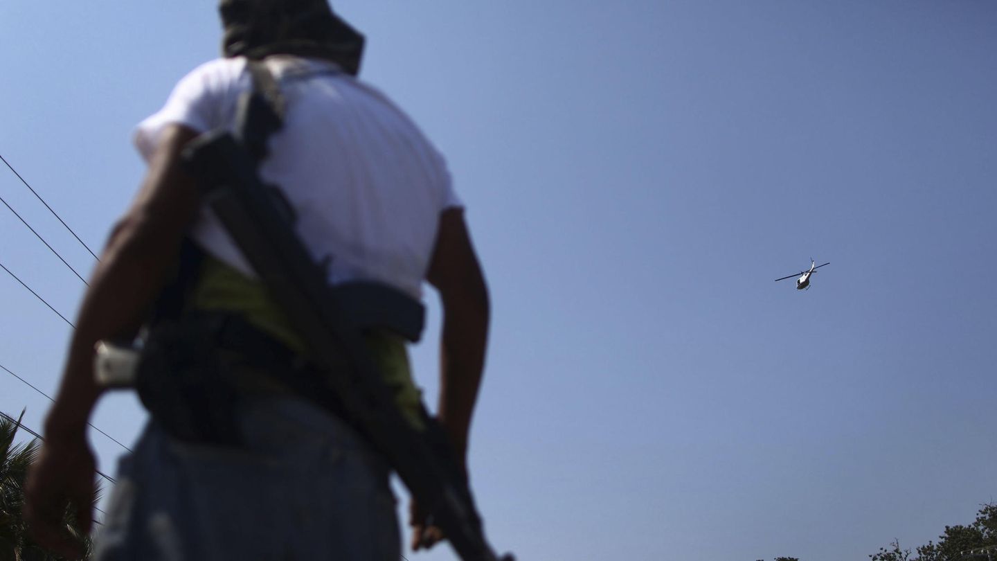 Un helicóptero de la Policía sobrevuela a un miembro de las autodefensas en Apatzingan (Reuters).