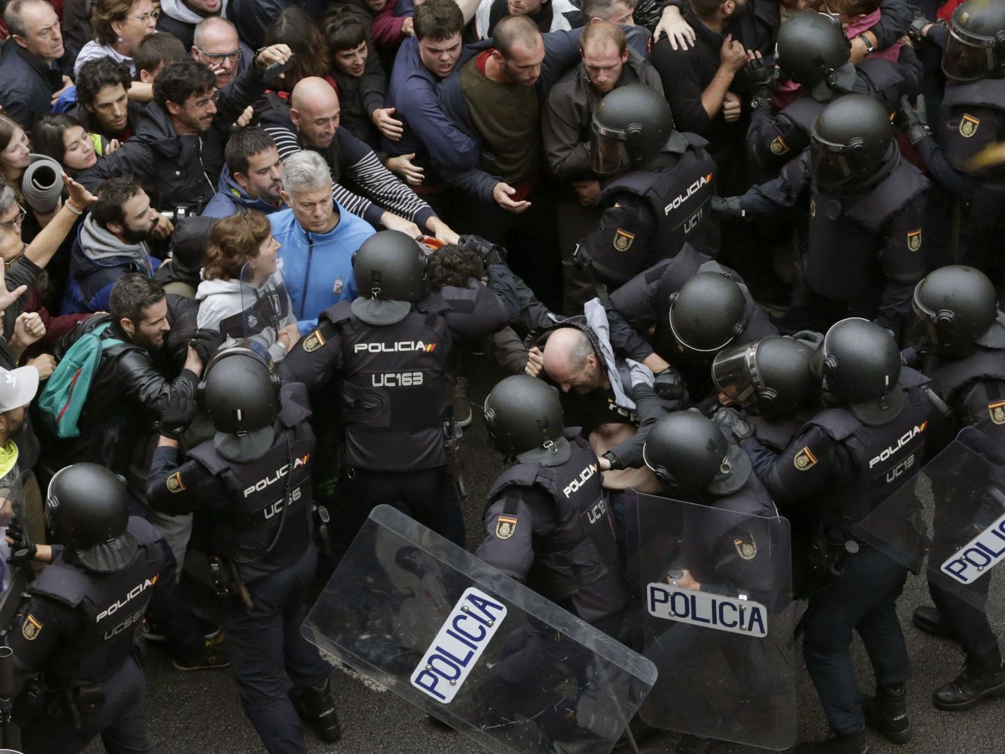 Agentes antidisturbios forman un cordón de seguridad ante el colegio Ramón Llull de Barcelona, este 1-O. (EFE)