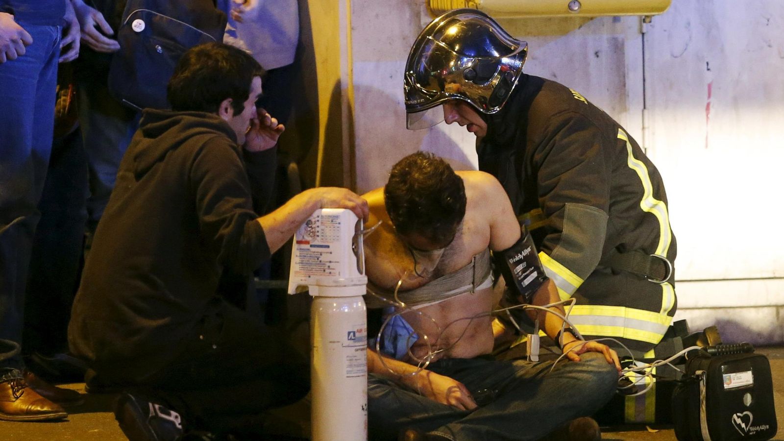 Foto: Un bombero atiende a uno de los heridos en los atentados de París. (Reuters)