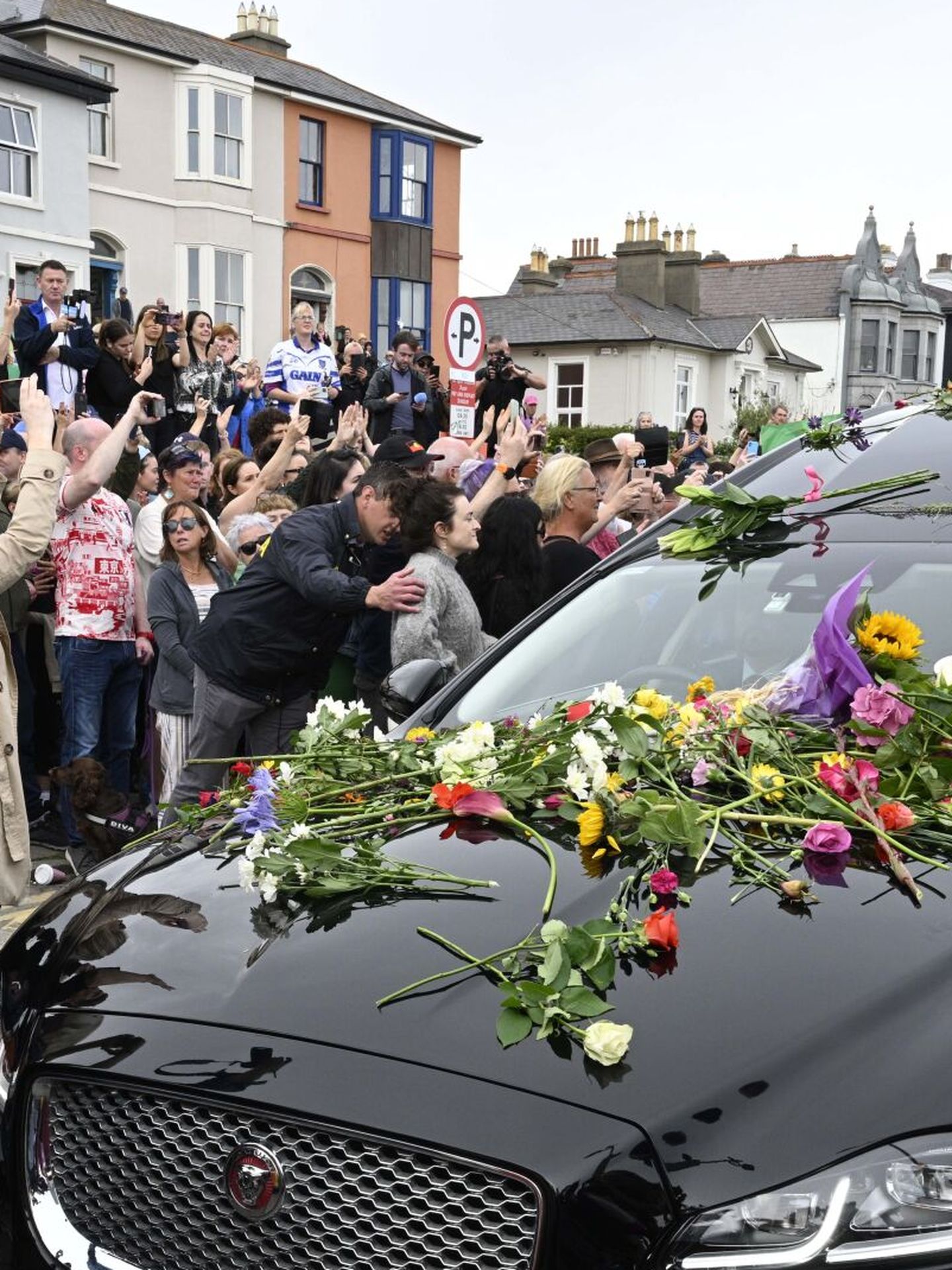 Fan alrededor del coche fúnebre en el último adiós a Sinéad O'Connor en Irlanda. (EFE/Bryan Meade)