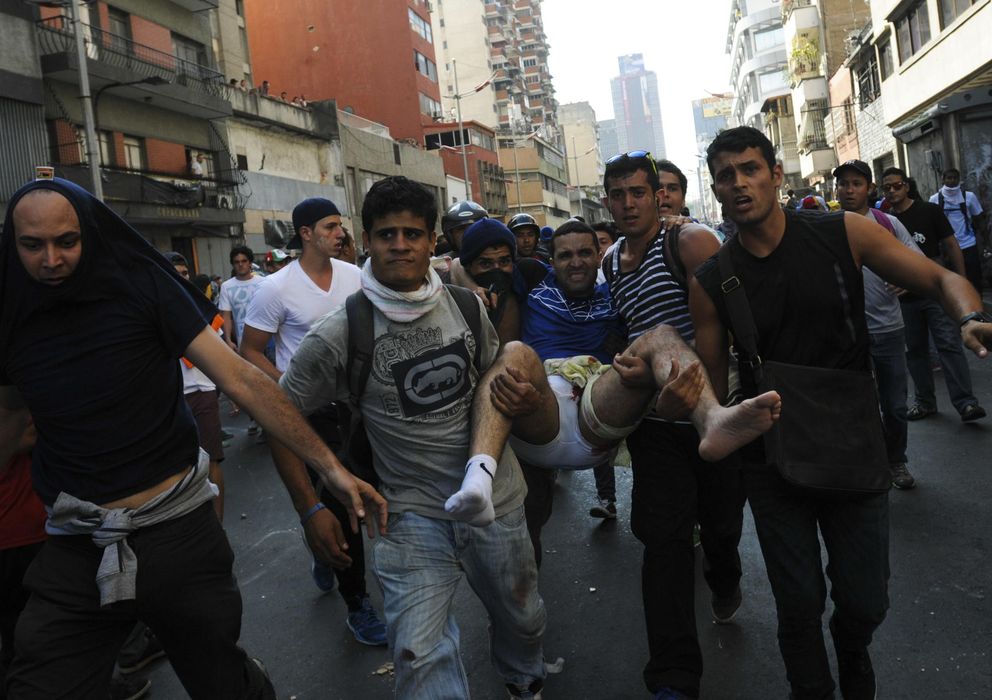 Foto: Un hombre herido es evacuado por otros manifestantes durante la protesta en Caracas (Efe).