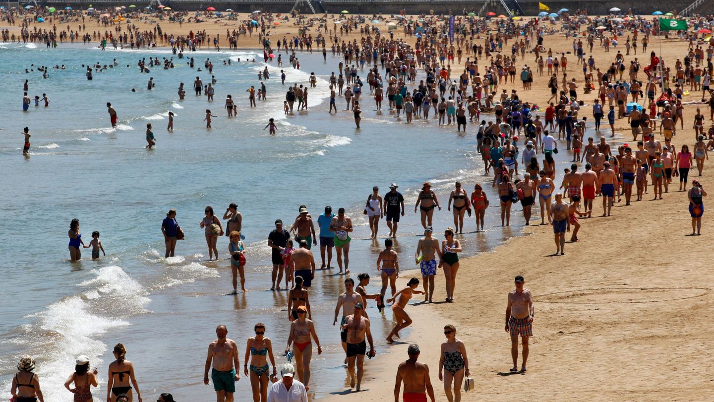 Decenas de personas disfrutan de un soleado día de verano en la playa de San Lorenzo en Gijón, el pasado 4 de julio. (EFE)