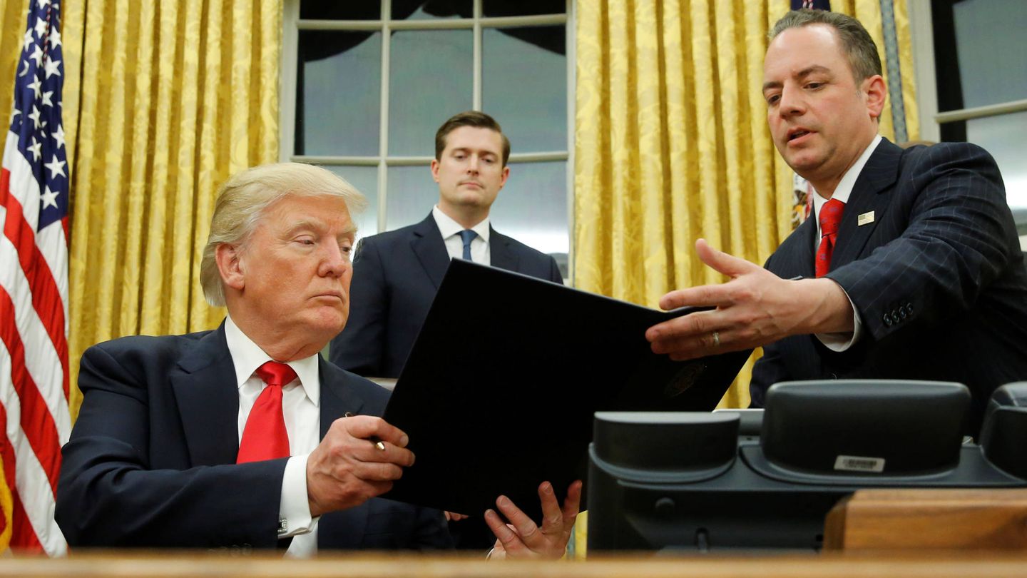 Donald Trump entrega a Reince Priebus la orden ejecutiva para desmantelar el Obamacare, en el Despacho Oval (Reuters).
