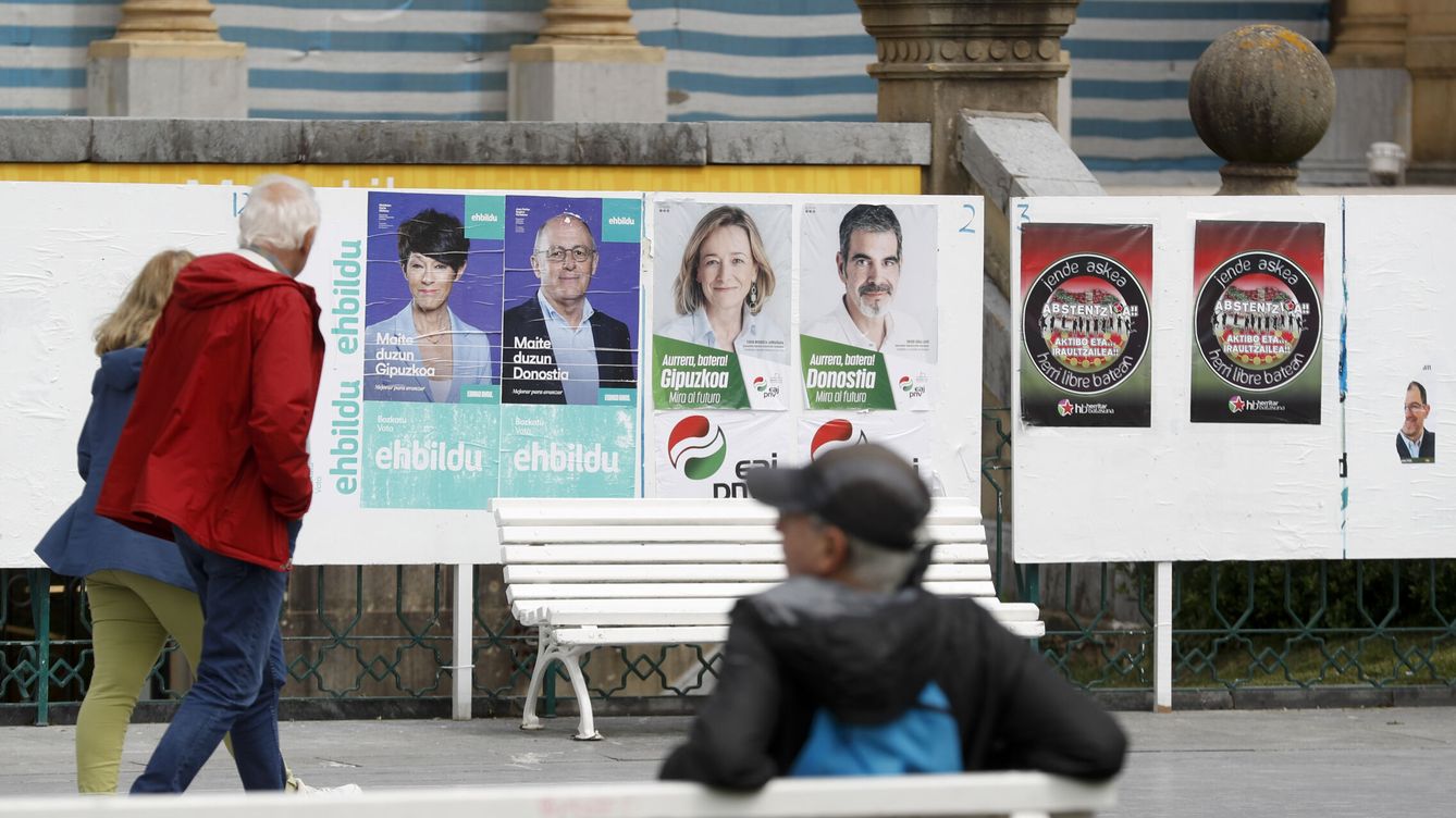 Foto: Unos ciudadanos observan varios carteles electorales el martes de la semana pasada en San Sebastián. (EFE/Juan Herrero)