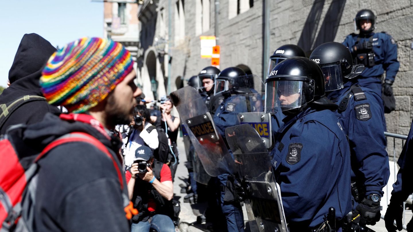 Manifestantes se encaran con los policías durante la cumbre del G-7 en Quebec, Canadá. (Reuters)