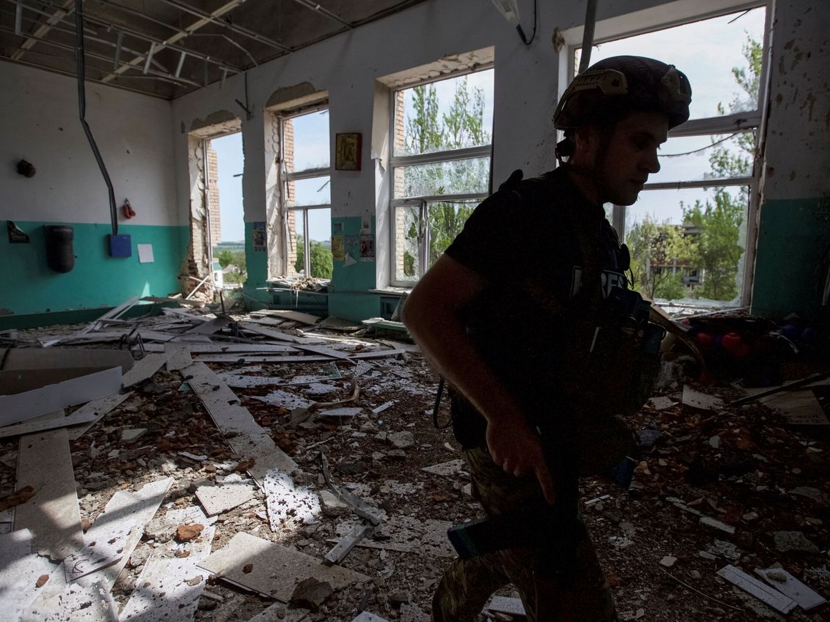 Foto: Un policía revisa una escuela tras un ataque ruso en la ciudad de Marinka. (Reuters/Anna Kudriavtseva)