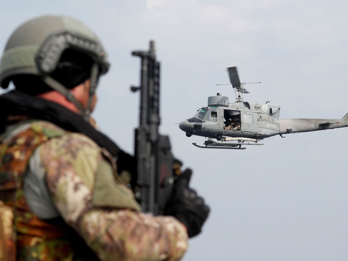 Foto: Un helicóptero vuela frente a un soldado de la Royal Navy británica durante un ejercicio militar de la OTAN. (Reuters)