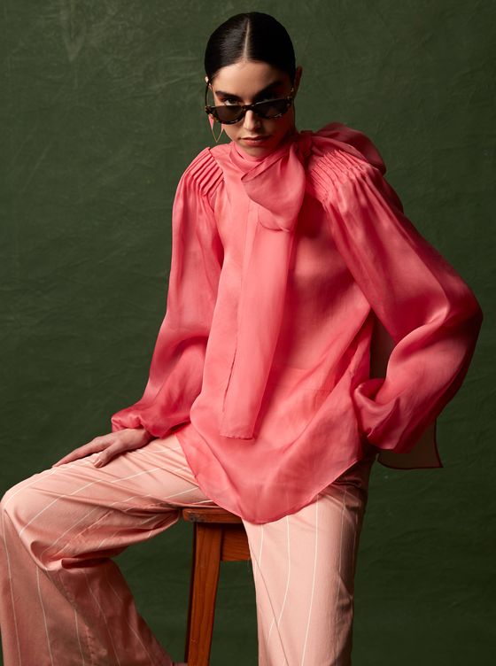 Blusa de gasa en rosa, de MASSIMO DUTTI. Pendientes, de IKKELELE. Gafas de ojo de gato, de UTERQÜE. Pantalón de rayas, de SAMSOE SAMSOE.