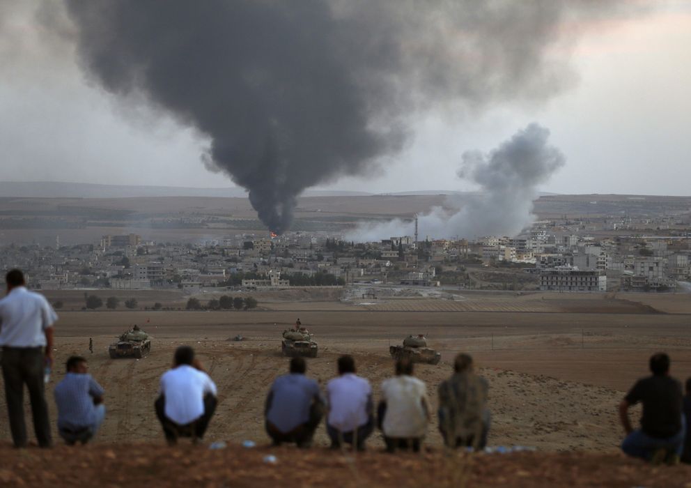 Foto: Kurdos observan desde territorio turco el humo provocado por los combates en Kobani durante la ofensiva del Estado Islámico (Reuters).